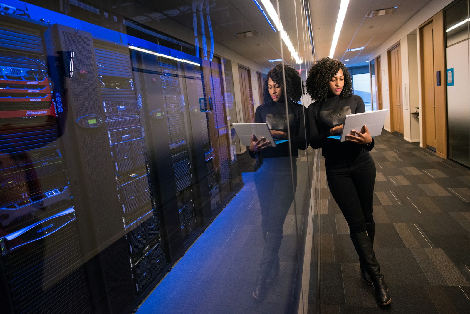 IT-Technikerin im Serverraum mit Tablet